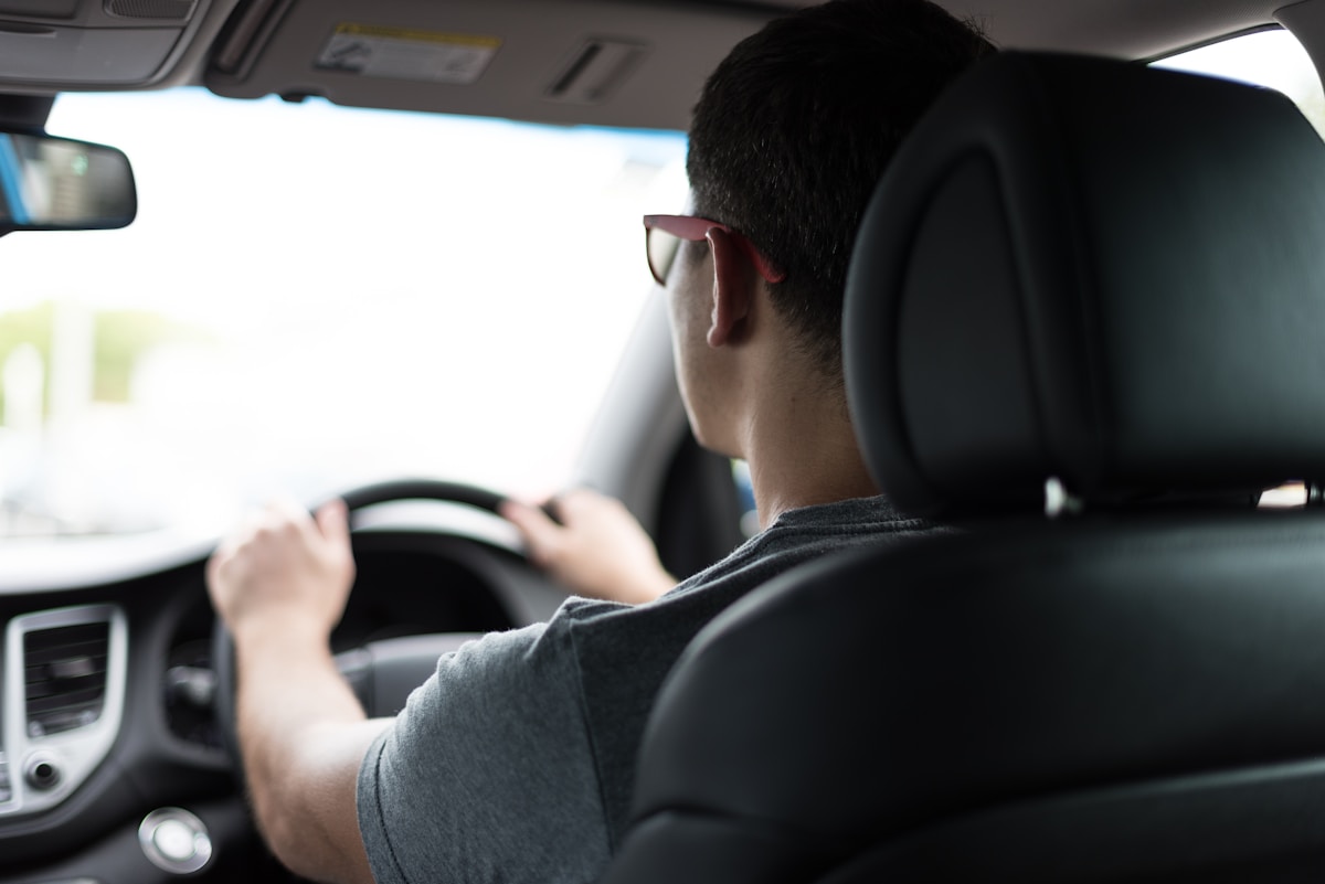 Instructor observing a learner from the car, hands on the wheel